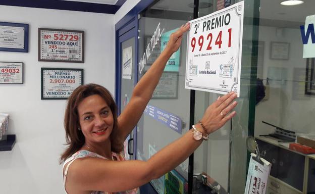 Inés Garzo cuelga el cartel de 2º premio de la lotería nacional